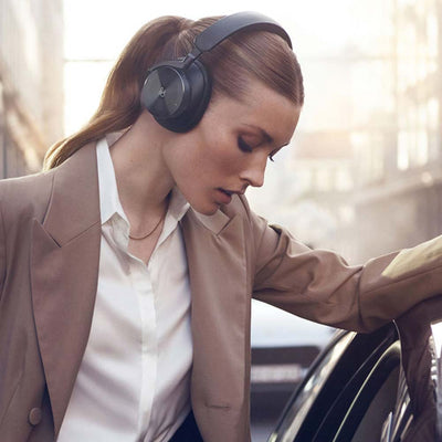 woman wearing beoplay h95 headphones in the street